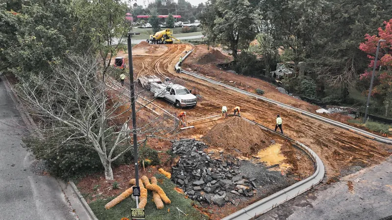 Crew finishing stone base inside new curb on a commercial pad