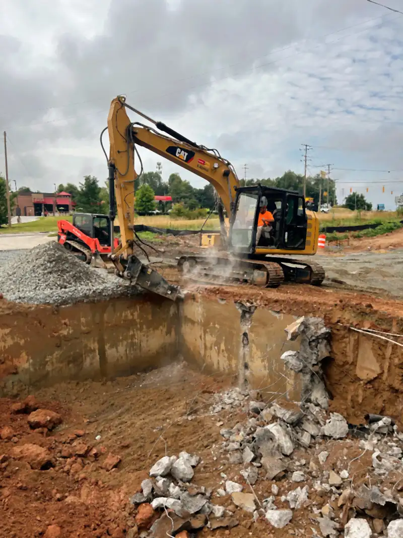 Excavator breaking out a concrete slab