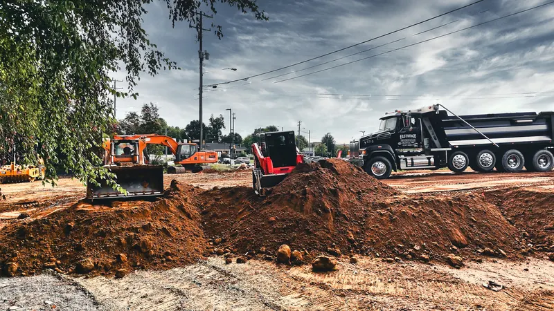 Dozer and dump truck building a graded pad