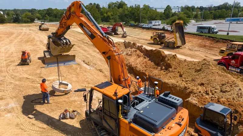 Aerial view of the graded site with crews placing stone base