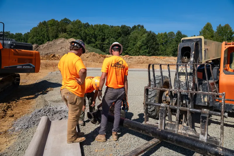 Crew staging water pipe beside the telehandler