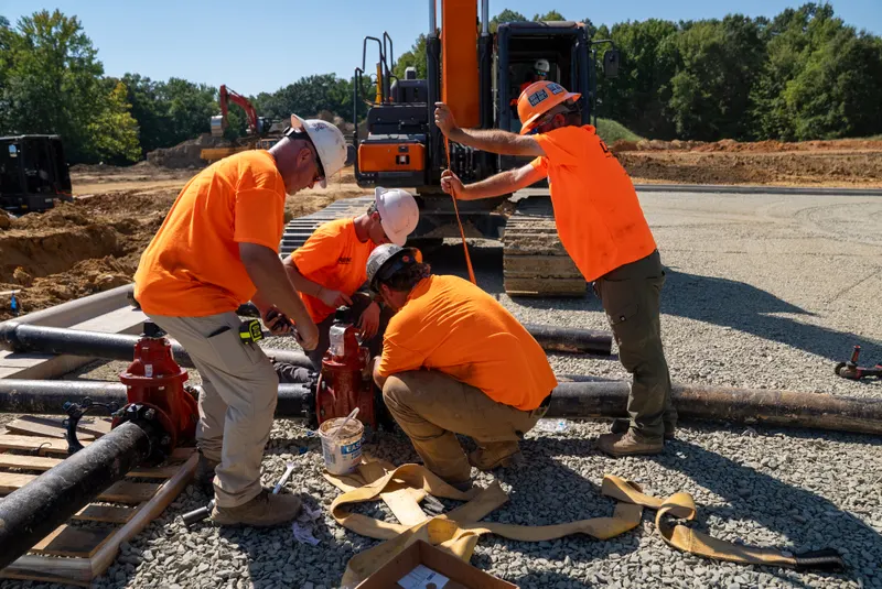 Crew assembling a gate valve on a water line