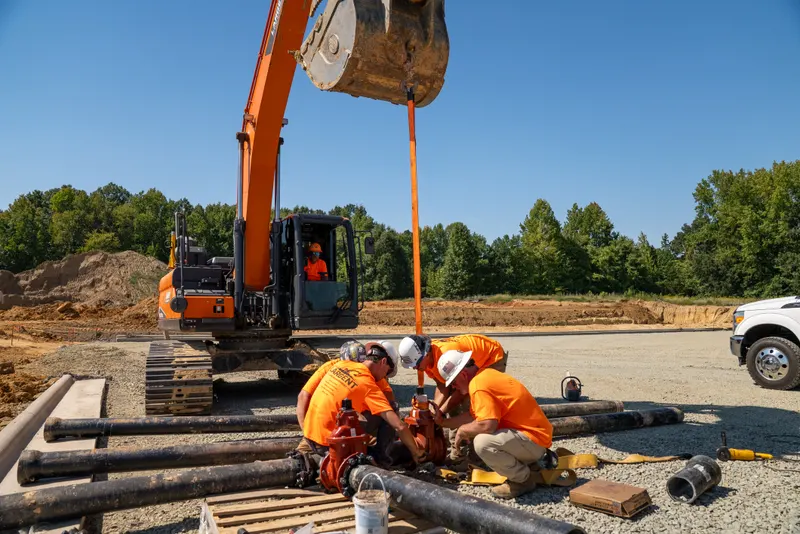 Largent crew lowering water pipe into a trench