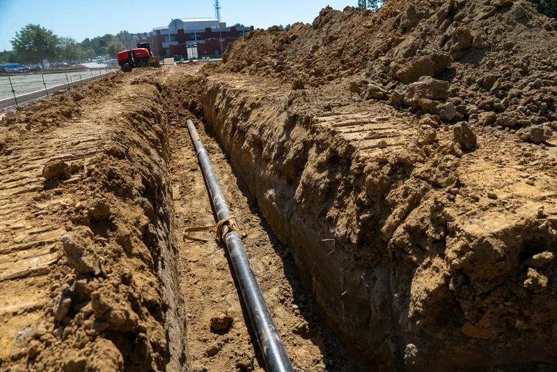 Long run of water pipe in a trench along the site
