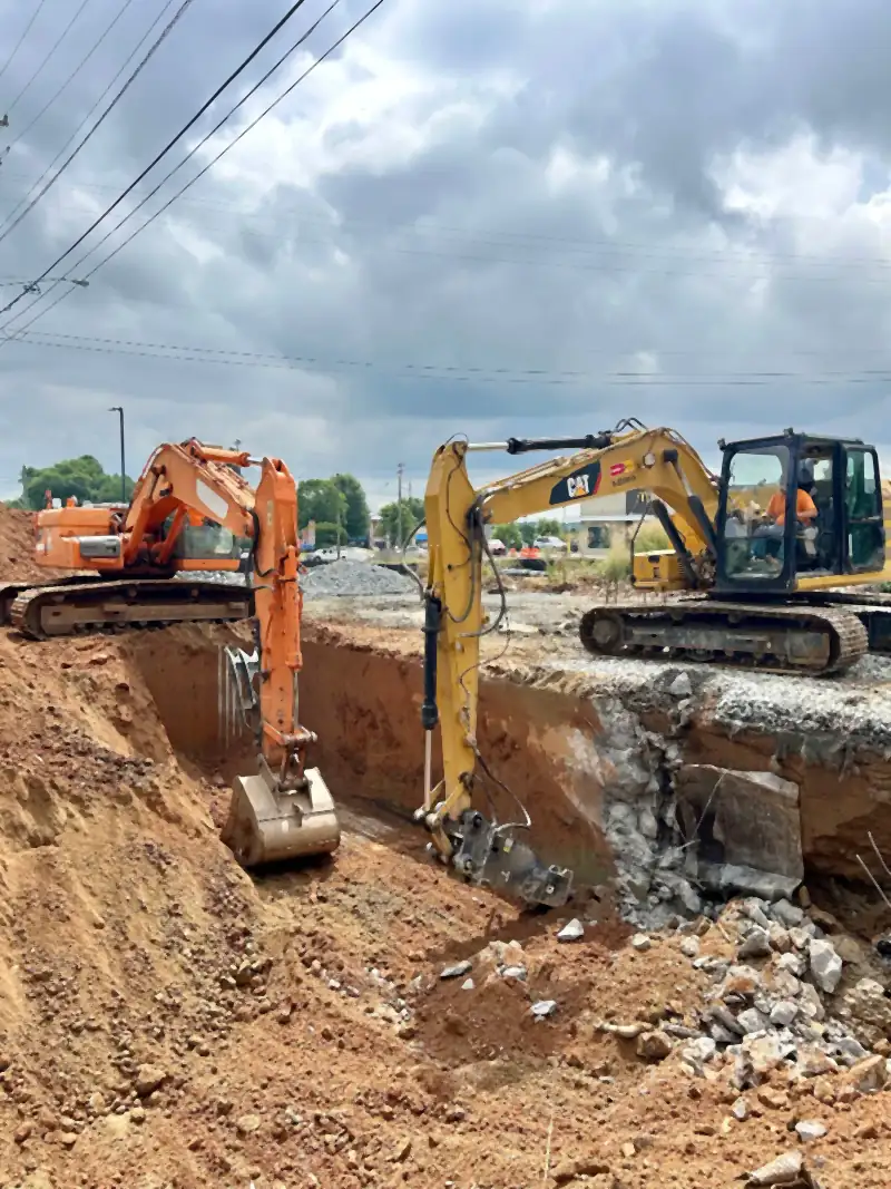 Two excavators opening a storm drain trench